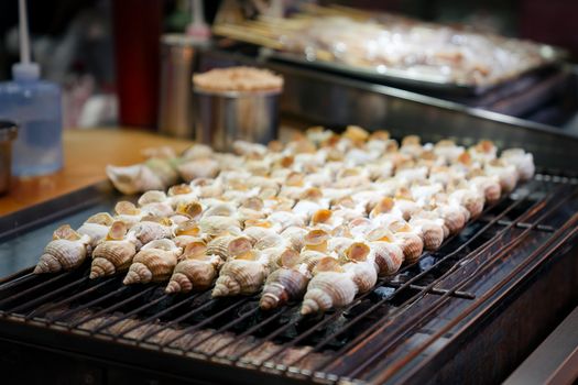 Street food, barbecue, conch shell grilled.