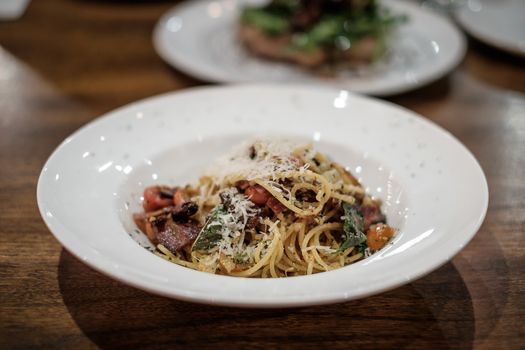 Spaghetti with olive oil, dry chili, and bacon, traditional Italian style.