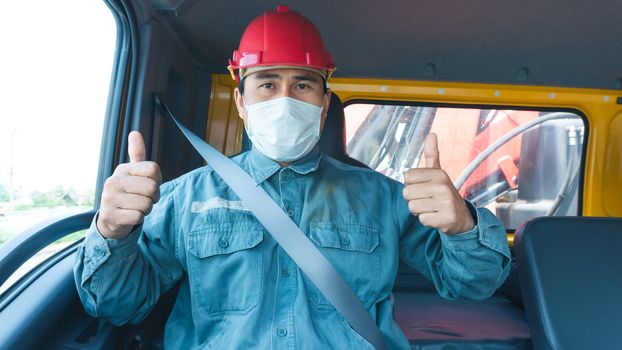 Close-up photos of Asian truck drivers wearing masks to protect against dust and the spread of the flu. Covid 19. Inside the car front