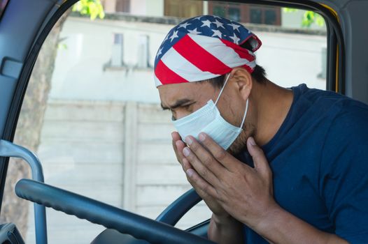 Close-up photos of Asian truck drivers wearing masks to protect against dust and the spread of the flu. Covid 19. Inside the car front