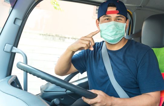 Close-up photos of Asian truck drivers wearing masks to protect against dust and the spread of the flu. Covid 19. Inside the car front