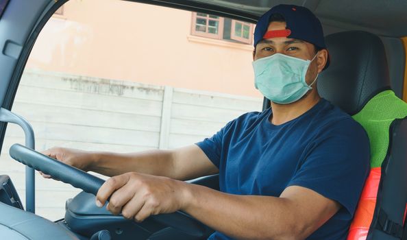 Close-up photos of Asian truck drivers wearing masks to protect against dust and the spread of the flu. Covid 19. Inside the car front