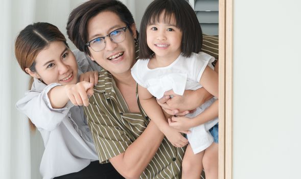 Asian family with cute parents and daughter. They are having fun playing in the bedroom.