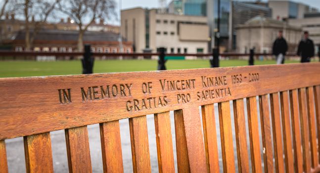 Dublin, Ireland - 11 February 2019: Wooden bench where it is written In memory of Vincent Kinane 1953 - 2000 in the city center on a winter day