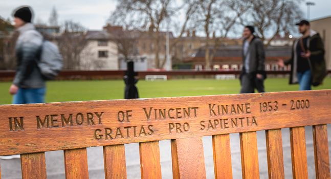 Dublin, Ireland - 11 February 2019: Wooden bench where it is written In memory of Vincent Kinane 1953 - 2000 in the city center on a winter day