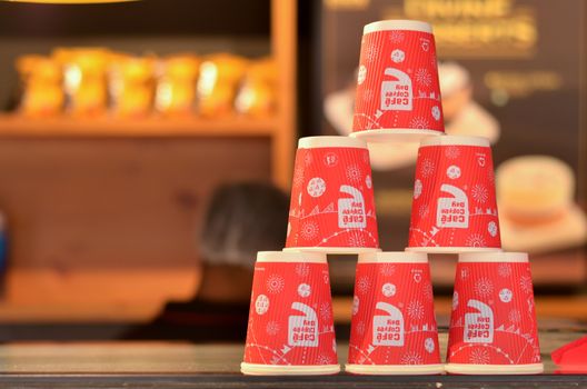 New Delhi, India, 2020. Red disposable cups with the CCD (Cafe Coffee Day) logo stacked on top of each other making pyramids on the counter for display and decor at the coffee shop.