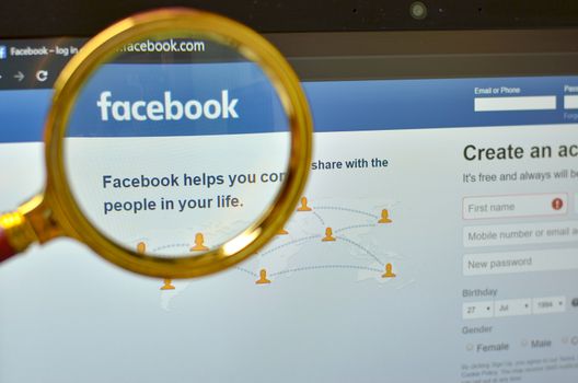 California, USA, 2020. Signup page of Facebook website open on a browser through a magnifying lens. Out of focus laptop screen is in the background. Concept Social Network