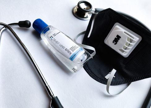 New Delhi, India, 2020. 3M Grey N95 face mask, sanitizer and stethoscope on a white background denoting doctor's Corona virus (Covid-19) safety kit to reduce the rate of spread of infections