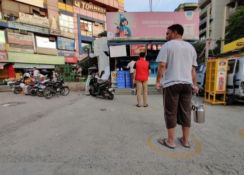 New Delhi, India, 2020. People trying to follow social distancing in long queues for stocking up essentials in front of grocery store during the Janta Curfew due to corona virus (covid-19) pandemic.