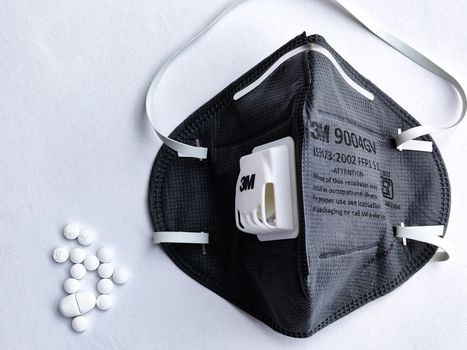 New Delhi, India, 2020. Selective focus of 3M Grey N95 face mask on a white background with medicine tablets for safety against Corona virus (Covid-19) pandemic to reduce the rate of spread