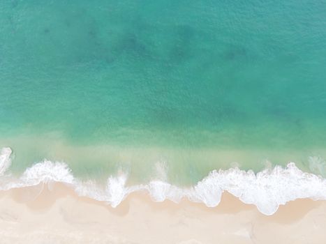 Aerial view top view Beautiful topical beach with white sand coconut palm trees and sea. Top view empty and clean beach. Waves crashing empty beach from above. With copy space.