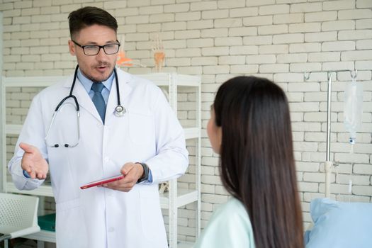 Photos of a male doctor taking care of a female patient and providing health care advice In the patient room of the hospital