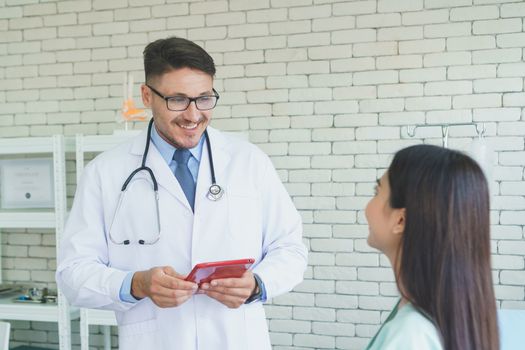 Photos of a male doctor taking care of a female patient and providing health care advice In the patient room of the hospital