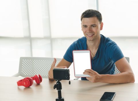 Caucasian men are having fun and being happy at home. He is doing a hobby by recording his own video clips using tablets and smartphones.