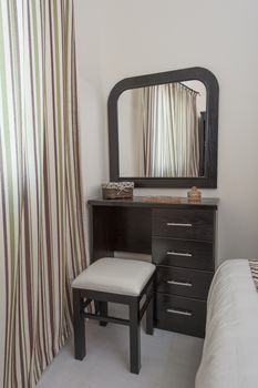Dressing table with stool and mirror in a bedroom
