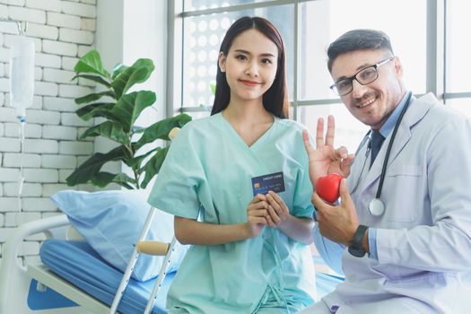 Photos of a male doctor taking care of a female patient and providing health care advice In the patient room of the hospital ( Mockup CREDIT CARD )