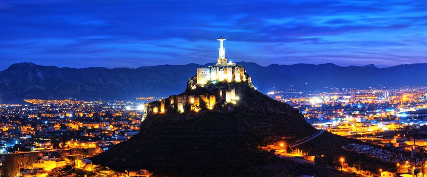 Panoramic view of Monteagudo Christ statue and castle at night in Murcia, Spain. Replica of the well-known Christ located on the top of the Concorvado Mountain in Rio de Janeiro