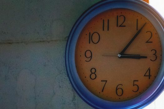 Yellow floor clock on blue cement wall