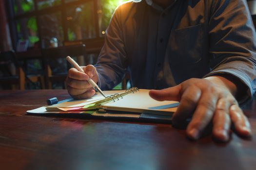 A picture of a business man sitting at a cafe talking in the afternoon of a bright day