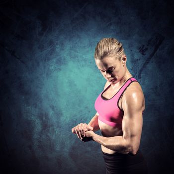 Muscular woman flexing her arm against dark background