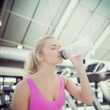 Composite image of beautiful healthy woman drinking water