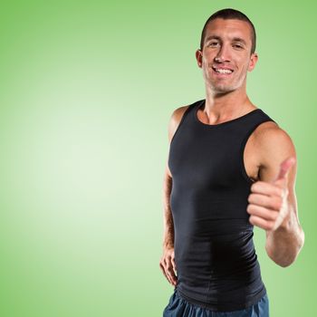 Happy athlete showing thumbs up against green vignette