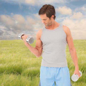 Fit young man exercising with dumbbells against nature scene