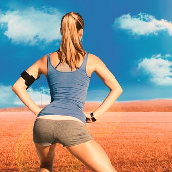 Pretty fit woman against sunny brown landscape