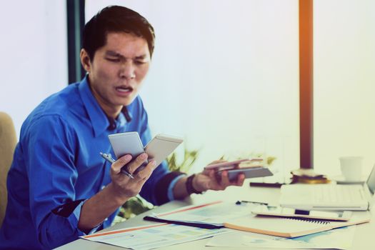 Stressed desperate businessman working in his office while there are many callers in his cellphone. business management concept