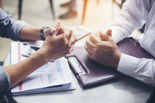 Interview or dialogue between businessman. Negotiation of two businessman with clasped hands in office.