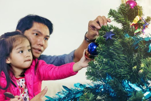 Father and son help to decorate the Christmas tree.