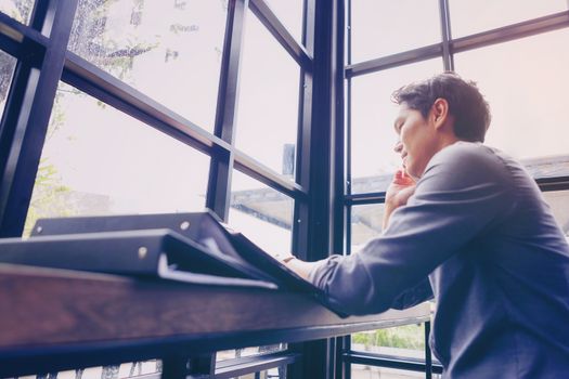 Young businessmen sit in business negotiations with their mobile phones and file a lot of paperwork.