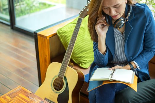 Beautiful girl is playing guitar by the window. Education lifestyle relax concept