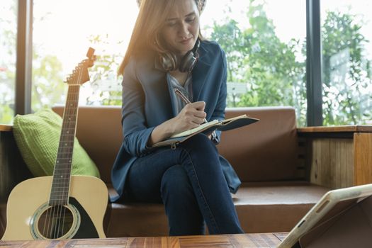 Beautiful girl is playing guitar by the window. Education lifestyle relax concept