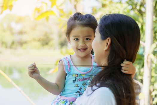 beautiful young mother and her daughter  in the park on a sunny summer day 