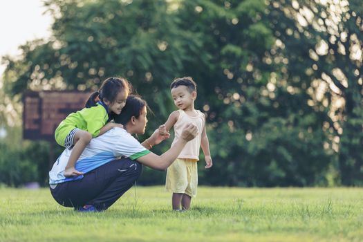 Happy family playing in the park. Mother and son play together in nature in the summer