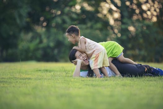 Happy family playing in the park. Mother and son play together in nature in the summer