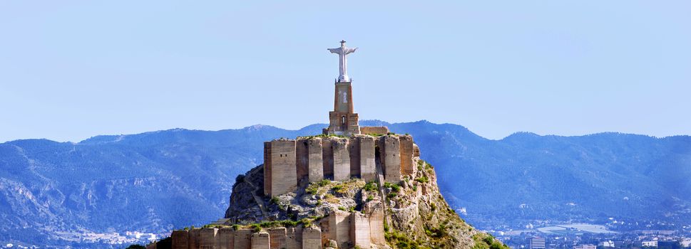 Panoramic view of Monteagudo Christ statue and castle at sunset in Murcia, Spain. Replica of the well-known Christ located on the top of the Concorvado Mountain in Rio de Janeiro.