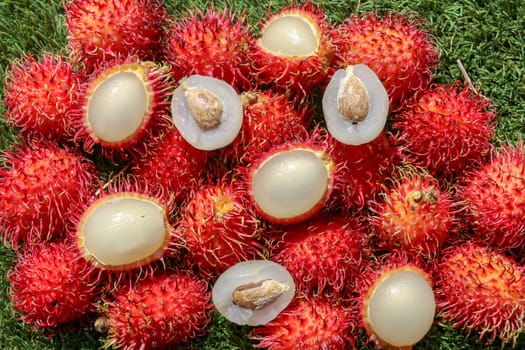 Full frame shoot of bunch of red rambutan fruits. Close up Rambutan peeled. Top view healthy fruits rambutans. The sweet fruit is a round to oval single-seeded berry covered with fleshy pliable spines