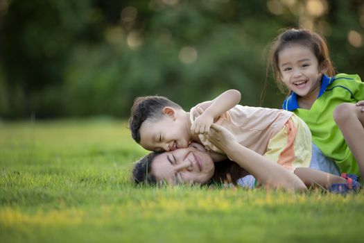 Happy family playing in the park. Mother and son play together in nature in the summer