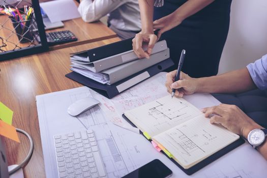 Male manager putting his ideas and writing business plan at workplace,man holding pens and papers, making notes in documents, on the table in office. selective focus.