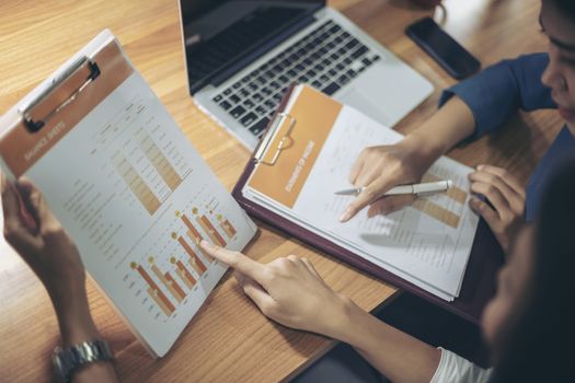 Businessman giving presentation on paper charts to colleagues in office. Business meeting time. Idea presentation, analyze plans.