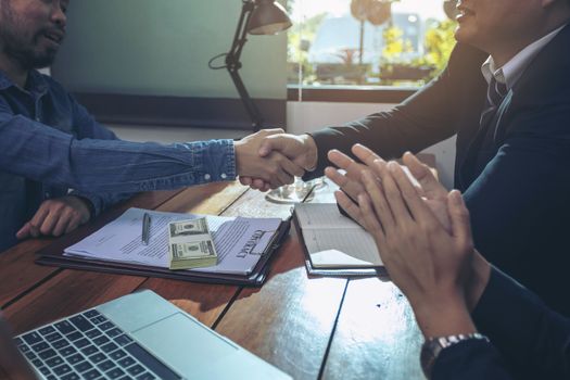 Happy smiling businessmen handshaking after signing contract meeting with businesswoman, sealing closing deal with satisfied client, bank customers come to negotiate a loan to invest.