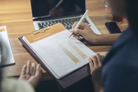 Businessman giving presentation on paper charts to colleagues in office. Business meeting time. Idea presentation, analyze plans.