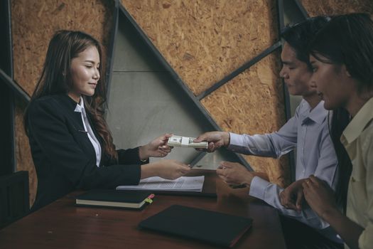 Businesspeople and partners shaking hands over the table, maintaining eye contact, confident entrepreneurs ready for effective negotiations, entering into a partnership, gender equality