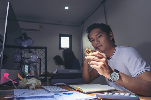 Asian businessmen thinking, worries about business, economy in office with money coins in the hand. Stressed businessman running out of money - stock and market down 
