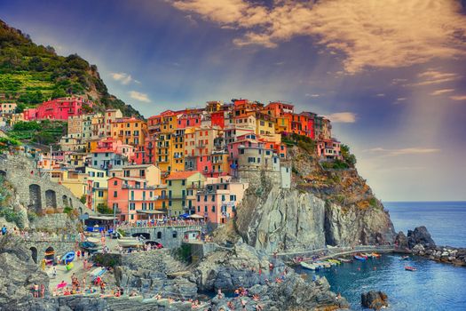 Manarola, Italy - July 9, 2018: Beautiful view of Manarola town, Cinque Terre, Liguria, Italy. People enjoying a day of sun and beach