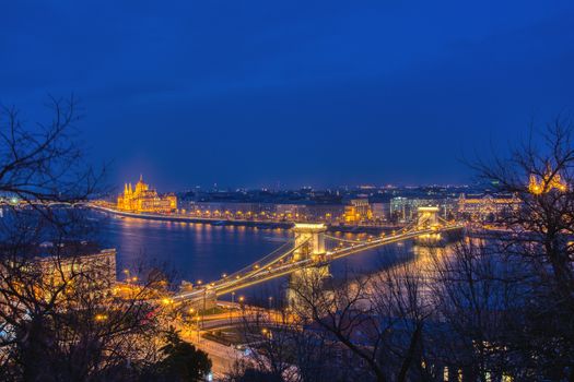 Budapest city night scene. View at Chain bridge, river Danube and famous building of Parliament. Budapest city is capital of Hungary.