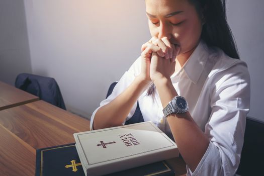 Women praying with bible Asian women believe in prayer with God beautiful Christian girl pray for a successful work. Christian life crisis prayer to god.