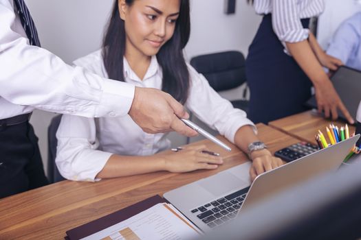 Executive mentor explaining intern or new employee  task pointing at computer screen, male boss supervisor teaching young girl to use corporate software or helping with difficult assignment